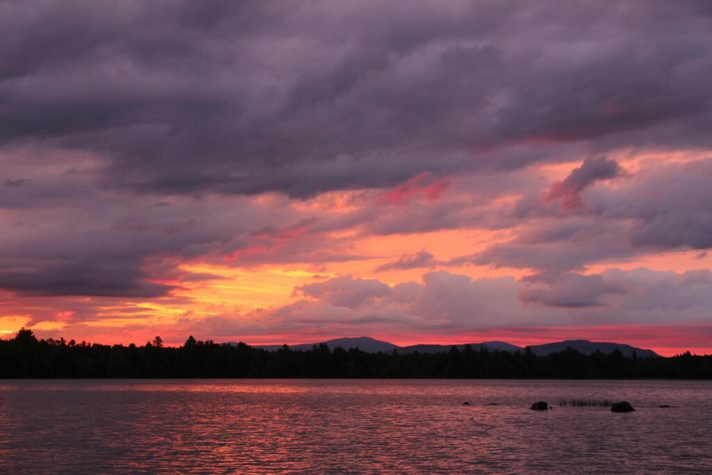 Vivid red, orange, pink and purple sunset over Lake Umbagog National Wildlife Refuge in New Hampshire