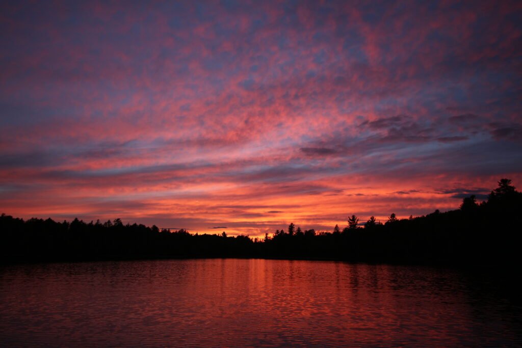 Soft purple evening light over Lake Umbagog National Wildlife Refuge with calm water